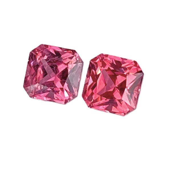 Two pink faceted gemstones with geometric cuts, placed side by side on a white background.