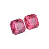 Cluster of pink faceted gemstones with angular cuts and light reflections.
