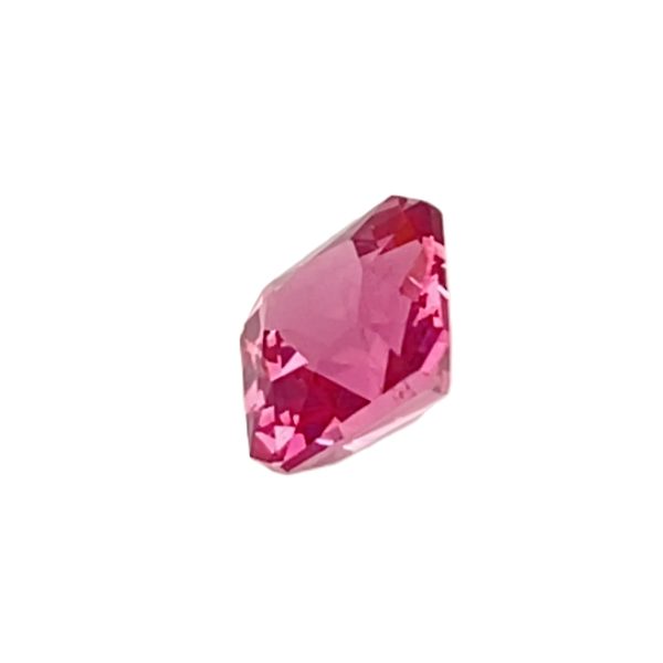 Pink faceted gemstone with a rectangular cushion cut on a white background.