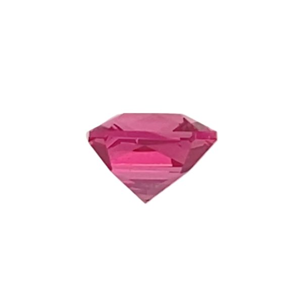 Partial view of a pink faceted diamond gemstone against a white background, showing triangular facets and a pointed bottom.