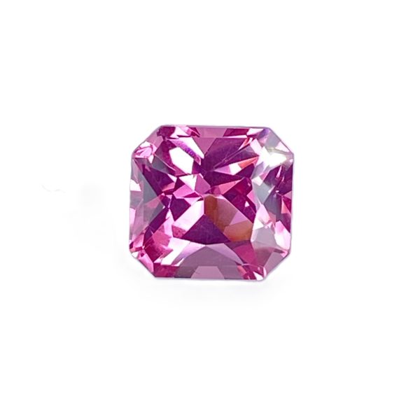 PSpin 16_2 - GEMWORLD LTD Close-up of a pink-purple faceted gemstone with multiple angular cuts against a white background.