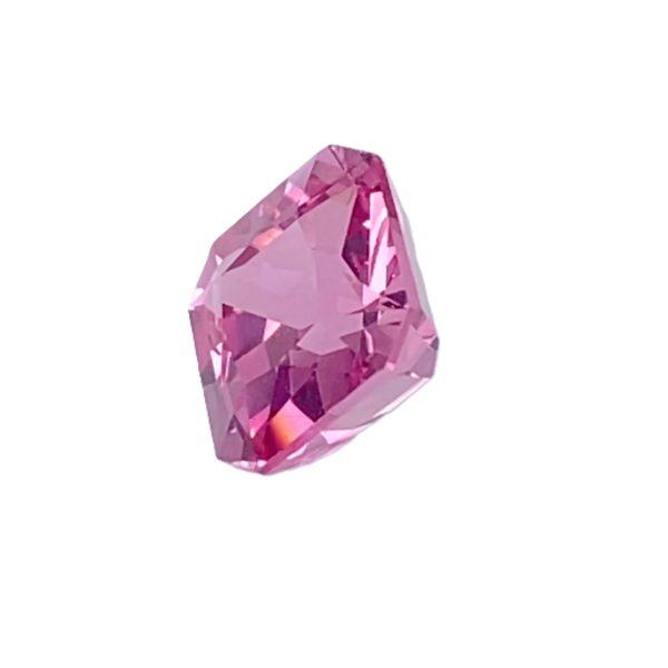 PSpin 16_5 - GEMWORLD LTD Close-up of a faceted pink gemstone against a white background, highlighting its cut facets and shine.”,