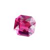 Close-up of a faceted pink gemstone reflecting light in sharp angular facets.