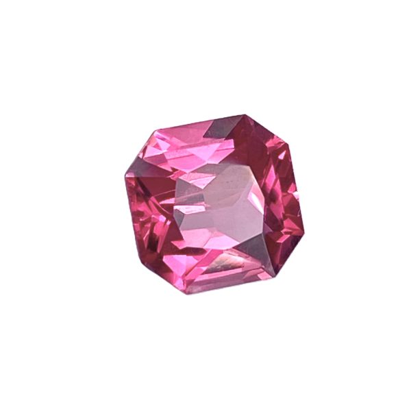 Close-up of a pink faceted gemstone with multiple sparkling facets against a white background