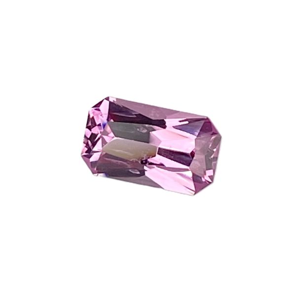 Fspin 239_1 - GEMWORLD LTD Close-up of a lavender-purple faceted gemstone set against a white background, showing its many angular faces.
