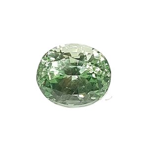 Close-up of a faceted green gemstone sphere against a white background.