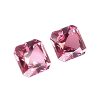 157_2 - GEMWORLD LTD Three pink faceted gemstones scattered on a white background and catching light at the edges