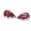 Tour 124125_1 - GEMWORLD LTD Two pink pear-cut gemstones with facets, placed facing each other on a white background (jewelry-like stones).