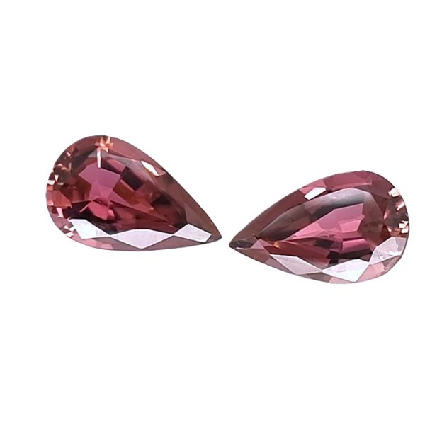 Tour 124125_1 - GEMWORLD LTD Two pink pear-cut gemstones with facets, placed facing each other on a white background (jewelry-like stones).