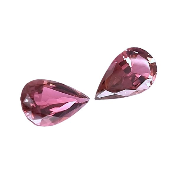 Tour 124125_2 - GEMWORLD LTD Two pink faceted teardrop gemstones on a white background.