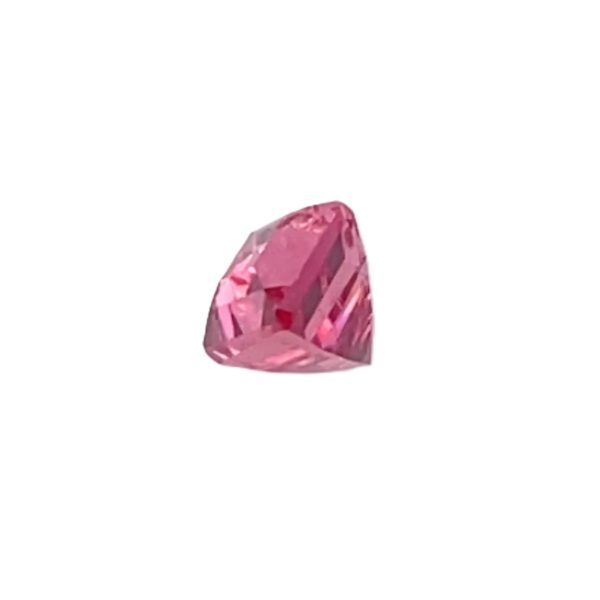 PSpin 113_5 - GEMWORLD LTD Partial close-up of a pink faceted gemstone on a white background, showing its shiny facets and pink color.