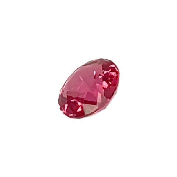 PSpin 118_5 - GEMWORLD LTD Close-up of a pink, oval-cut faceted gemstone on a white background, showing multiple facets and refractions.