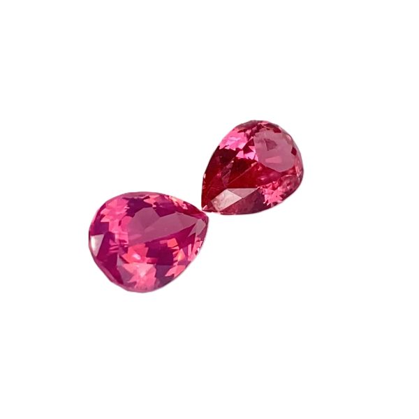 PSpin 138_5 - GEMWORLD LTD Three pink faceted gemstones arranged diagonally on a white background for a jewelry-themed image.