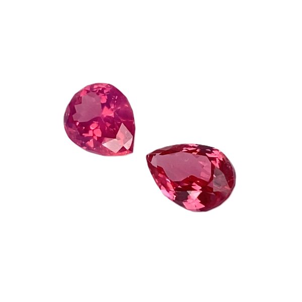 PSpin 138_6 - GEMWORLD LTD Three pink faceted gemstone beads arranged diagonally on a white background, showing sparkly facets.