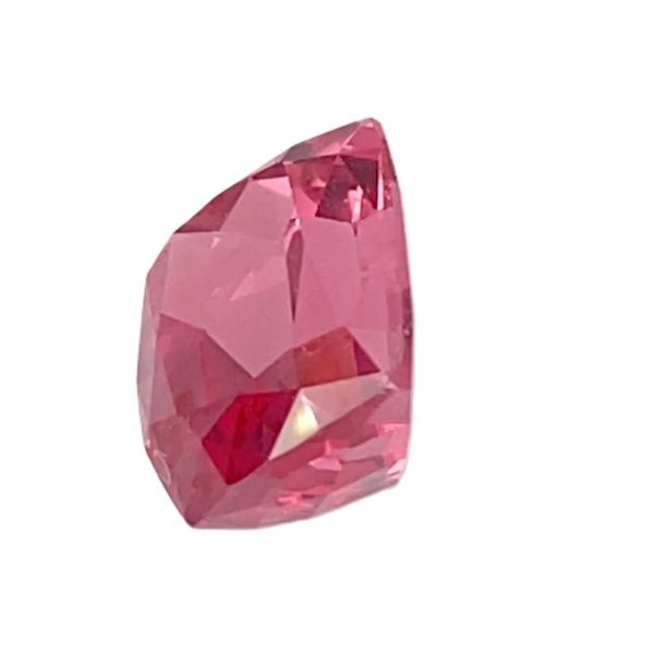 PSpin 59_5 - GEMWORLD LTD Close-up of a pink faceted gemstone with angular surfaces against a white background.