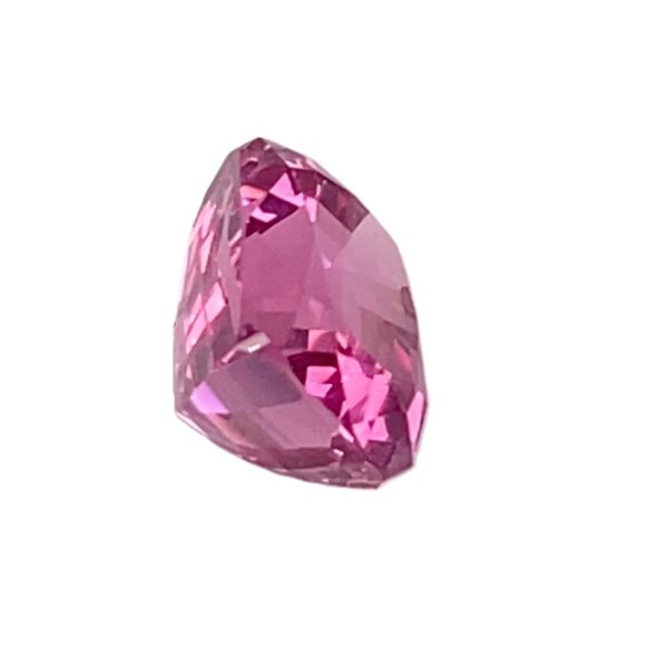 PSpin 71_7 - GEMWORLD LTD Close-up of a pink faceted gemstone crystal with angular facets against a white background.