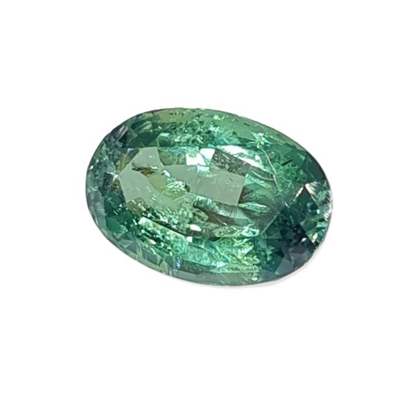 Korn 158_1 - GEMWORLD LTD Close-up of a green, faceted gemstone sphere with reflective facets and light reflections