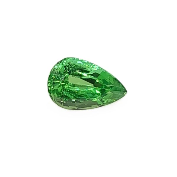 Close-up of a faceted emerald-green gemstone on a white background, sparkling with light reflections.