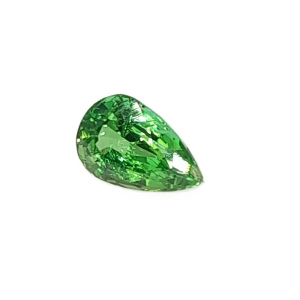 Close-up of a green faceted teardrop emerald against a white background.