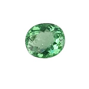 Green faceted gemstone sphere on a white background, close-up view of the emerald-like ball.