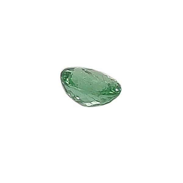 Par 16_6 - GEMWORLD LTD Green oval-cut gemstone with faceted surface on a white background, showing brilliant facets and depth.