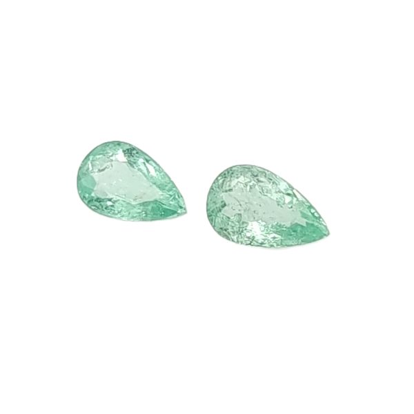 Three green gemstone pebbles arranged along the bottom edge of the frame. They have a faceted, crystalline texture and pale green hues.