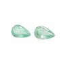 Two green pear-shaped emeralds resting on a white background.