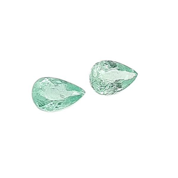 Three irregular green stones scattered on a white background.