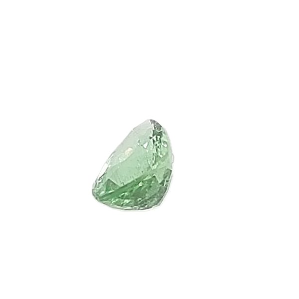 Close-up of a pale green crystal shard with rough facets and irregular edges