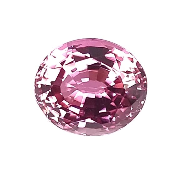 Close-up of a round pink faceted gemstone with multiple light-reflecting facets