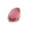 Close-up of a pink faceted gemstone isolated on white background with many angular facets.