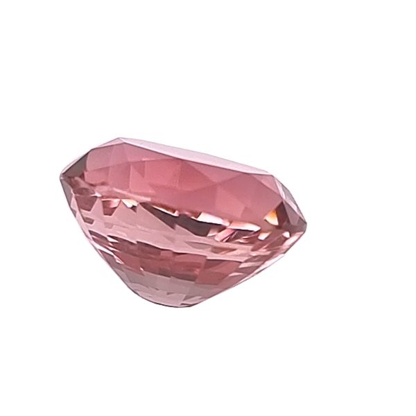 Pink faceted gemstone shown in the bottom-left corner against a white background, highlighting its geometric facets.