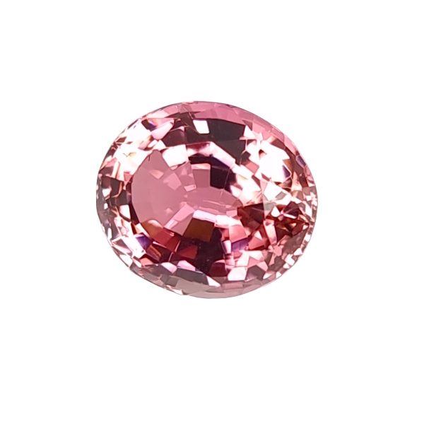 Close-up of a round pink gemstone with many facets catching the light.