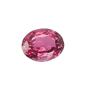 Close-up of a pink faceted gemstone sphere with many angular facets catching light at the bottom edge of the image.