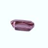 Tour 129_3 - GEMWORLD LTD Close-up of a faceted pink gemstone against a pale background, showing its angular cuts and reflective facets.