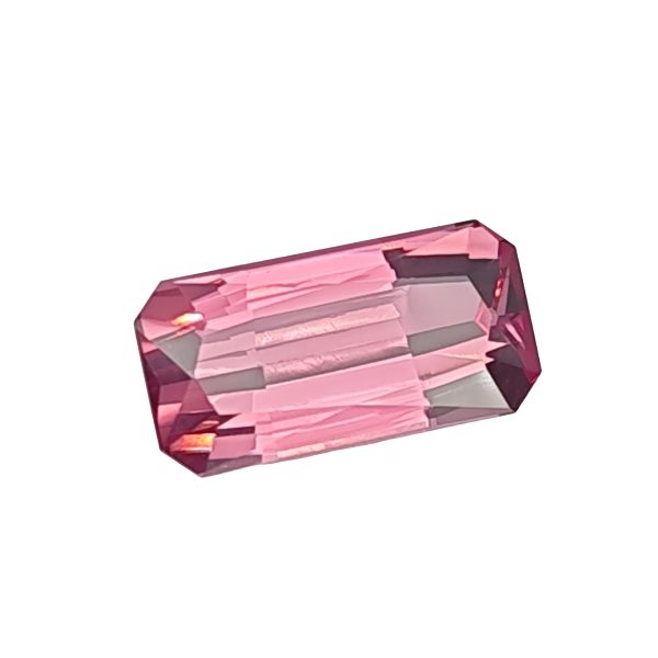 Tour 134_5 - GEMWORLD LTD Close-up of a faceted pink gemstone with angular, geometric facets against a white background.