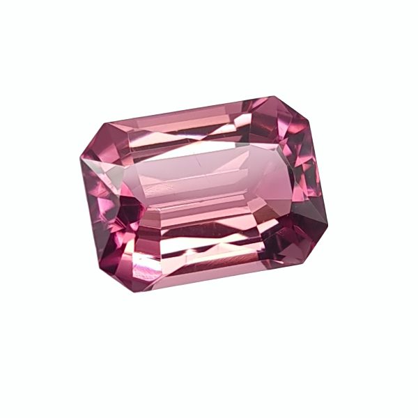 Close-up of a pink/purple faceted gemstone with sharp cuts and reflections.