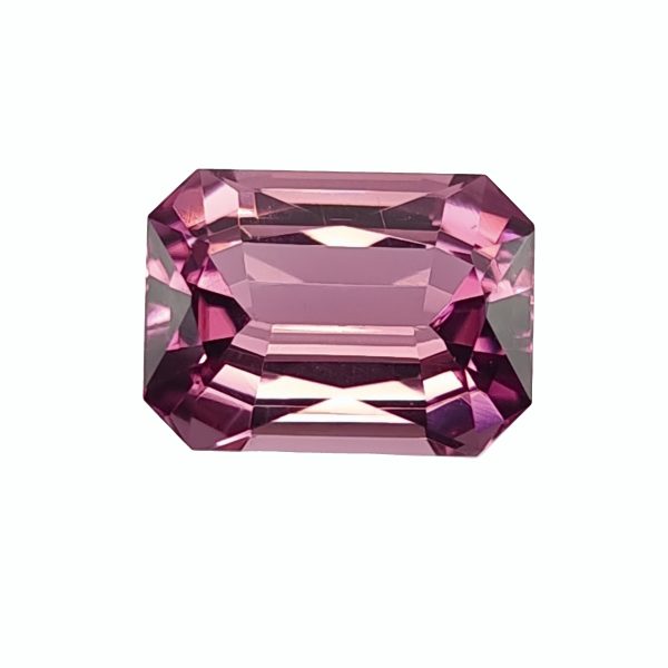 Close-up of a pink, faceted gemstone with many reflective facets on a white backgroundesh