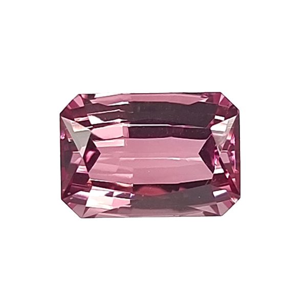 Close-up of a pink-red faceted gemstone with an octagonal cut on a white background.