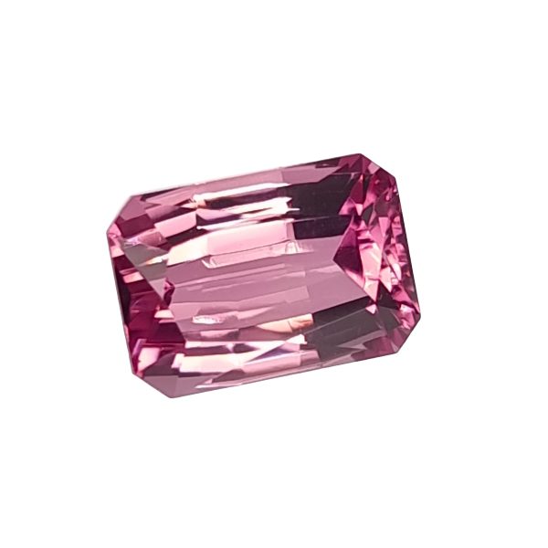 Close-up of a faceted pink gemstone with multiple angular facets against a white background.