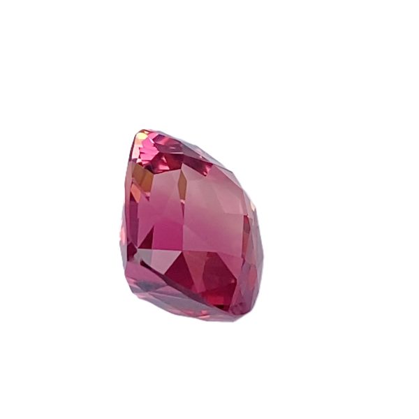Tour 2_7 - GEMWORLD LTD Pink faceted gemstone against a white background, showing multiple angular facets