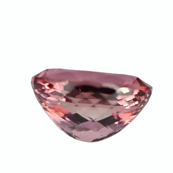 Tour 36_2 - GEMWORLD LTD Close-up of a pink faceted gemstone with sparkly facets reflecting light in a rounded cut.