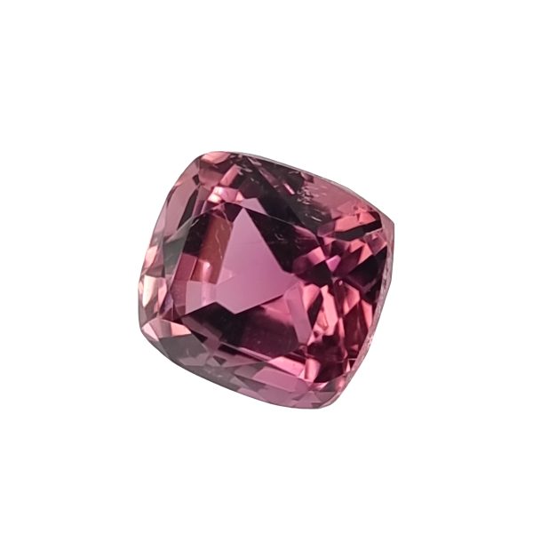 Close-up of a teardrop-shaped pink gemstone with many facets on a white background.