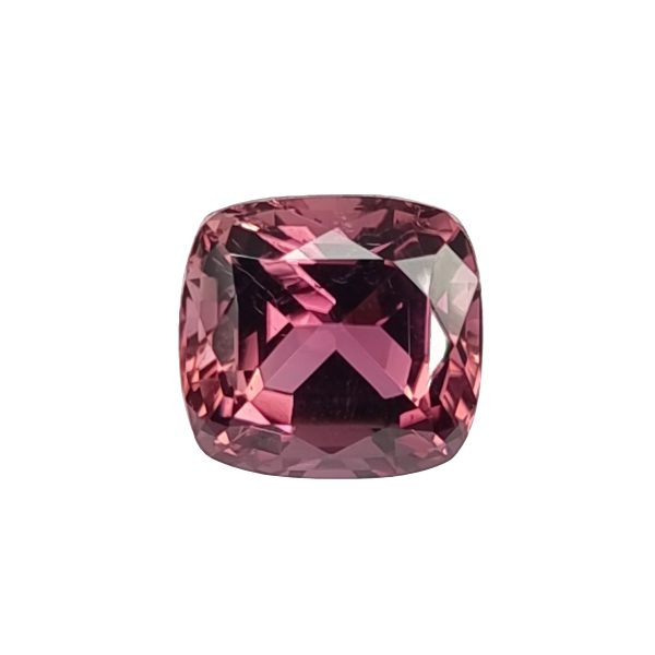 Close-up of a faceted pink gemstone with a rounded rectangular cut, showing rich pink and purple facets catching light
